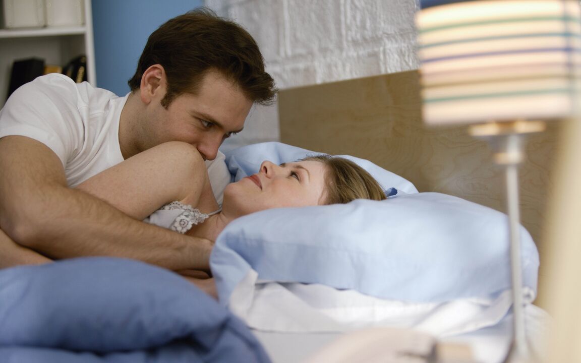 a woman in bed with a man who has enlarged his penis
